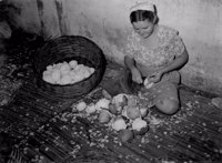 Mulher quebrando coco em Aracaju (SE)