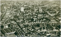 Vista aérea da cidade : [Edifício Abdo Najar : Basílica de Santo Antônio de Pádua] : Americana, SP