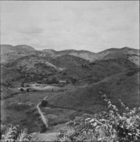 Topografia ondulada e sede de fazenda ao fundo de um vale : encosta com plantação de cana a direita : Município de Macuco (RJ)